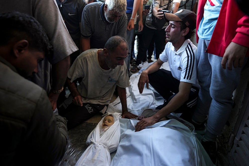 Palestinians mourn for relatives killed in the Israeli bombardment of the Gaza Strip at a hospital morgue in Deir al-Balah, on October 2, 2024. (AP)