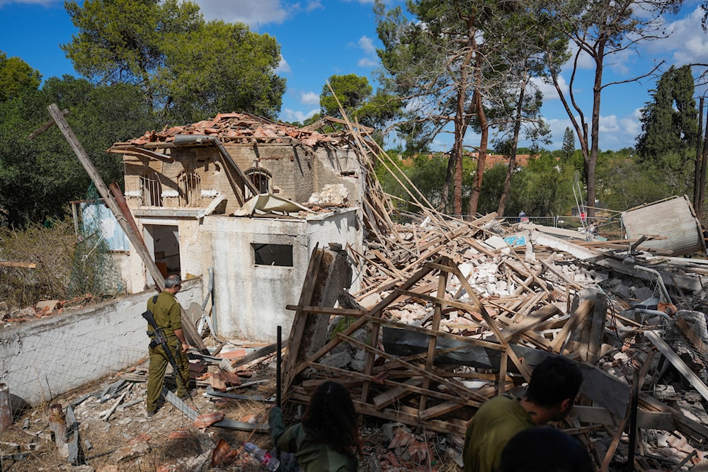 Israeli soldiers look at a destroyed building that was hit in Iran's retaliatory attack in Hod Hasharon, 