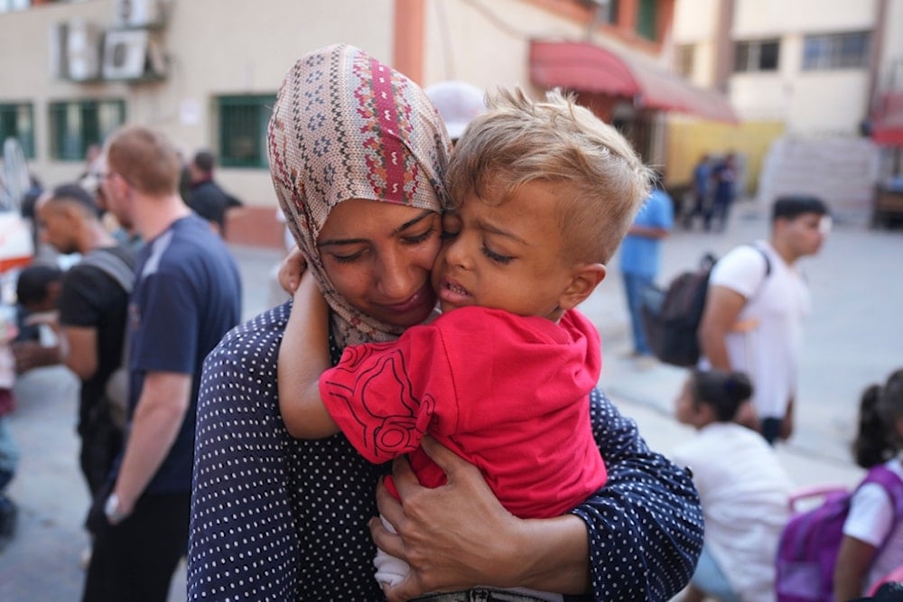 A Palestinian woman says goodbye to her sick son before leaving the Gaza Strip to get treatment abroad, southern Gaza Strip, Thursday, June 27, 2024 (AP)