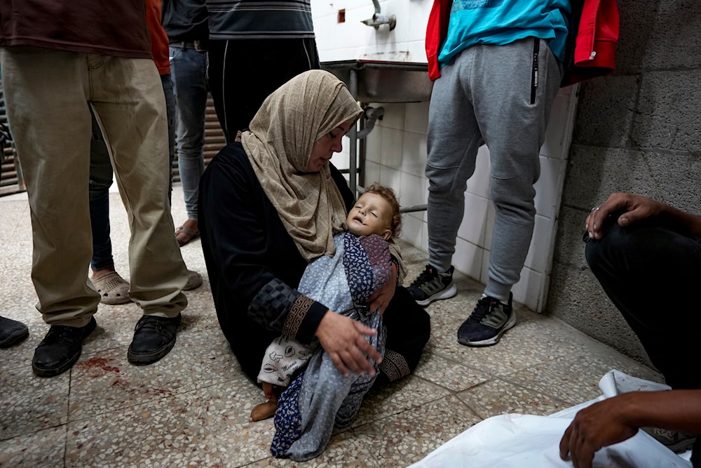 A Palestinian woman mourns a child killed in the Israeli bombardment of the Gaza Strip at a hospital morgue in Deir al-Balah, Wednesday, Oct. 2, 2024. (AP)