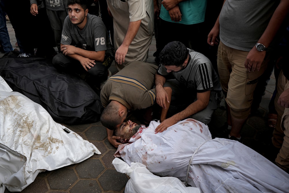 Palestinians mourn their relatives killed in the Israeli bombardment of the Gaza Strip at a hospital morgue in Deir al-Balah, on October 8, 2024. (AP)