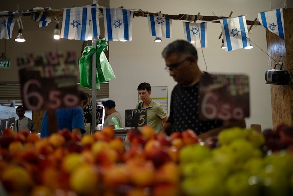 People buy fruits and vegetables in a local market in Haifa, occupied Palestine, Friday, Aug. 16, 2024. (AP)