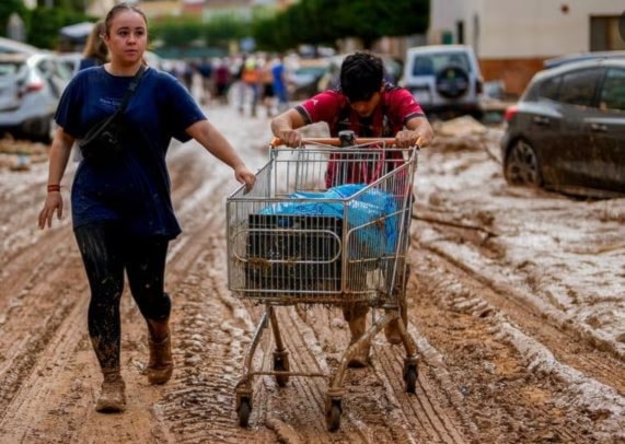 Two people push a cart loaded with belongings in Utiel. (AP)