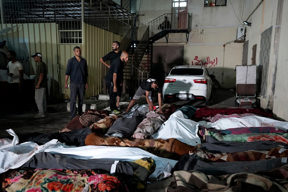  Palestinians check the bodies of their relatives killed in an Israeli bombardment of UNRWA school at Nusseirat refugee camp, in front of the morgue of al-Aqsa Martyrs hospital in Deir al-Balah, central Gaza Strip, June 6, 2024. (AP)