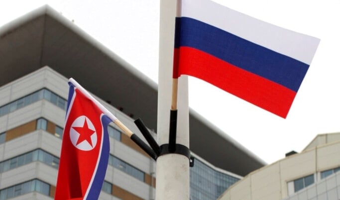 Flags of Russia, right, and North Korea are seen along the road on Russky Island, in Vladivostok, Russia, Tuesday, April 23, 2019.