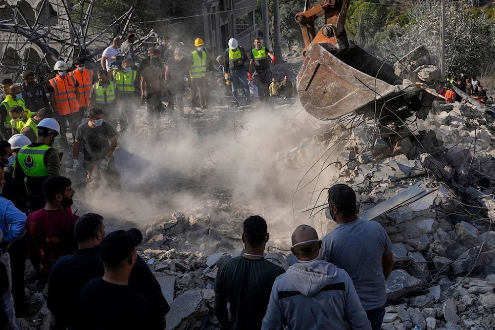 Rescue workers and people search for victims under the rubble of a destroyed house hit in an Israeli airstrike, in Almat village, northern Lebanon, Sunday, November 10, 2024 (AP)