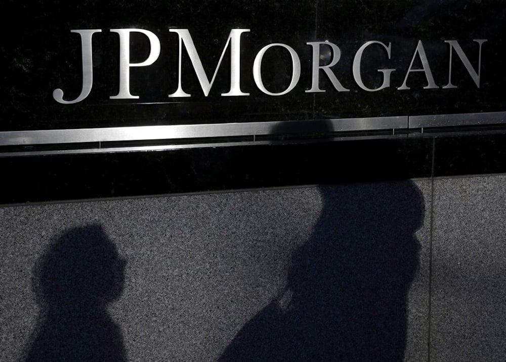 Shadows of pedestrians are cast over a sign in front of JPMorgan Chase & Co. headquarters in New York, Tuesday, Nov. 19, 2013. (AP)