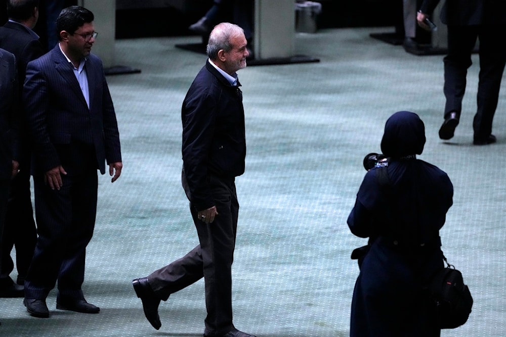 Iranian President Masoud Pezeshkian walks towards the podium to speak in an open session of parliament to debate on his next year's budget bill, in Tehran, Iran, Tuesday, October 29, 2024 (AP)