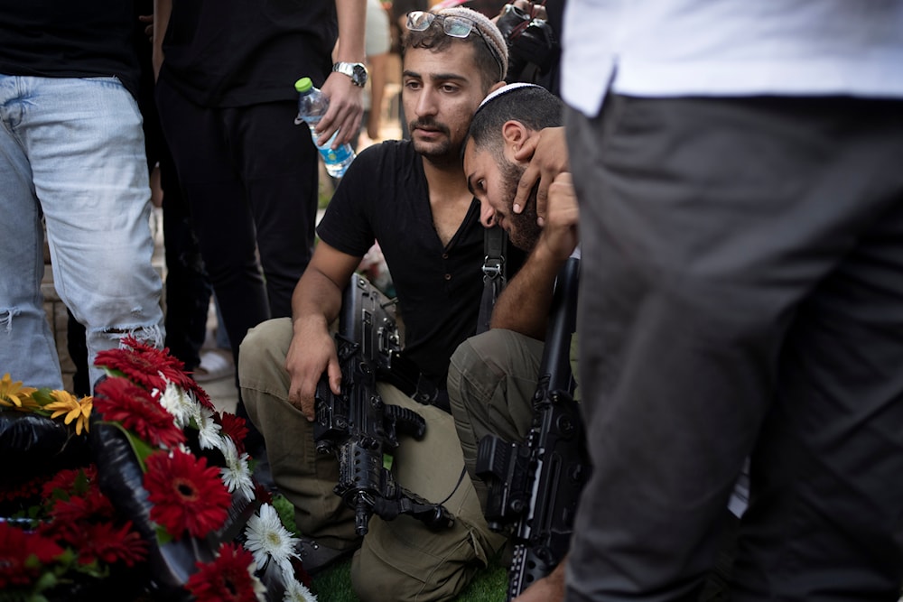 Soldiers visit the grave of Israel Defense Forces Captain Elad Siman Tov, who was killed in action in Lebanon, during his funeral in Petah Tikva, occupied Palestine, on October 18, 2024. (AP)