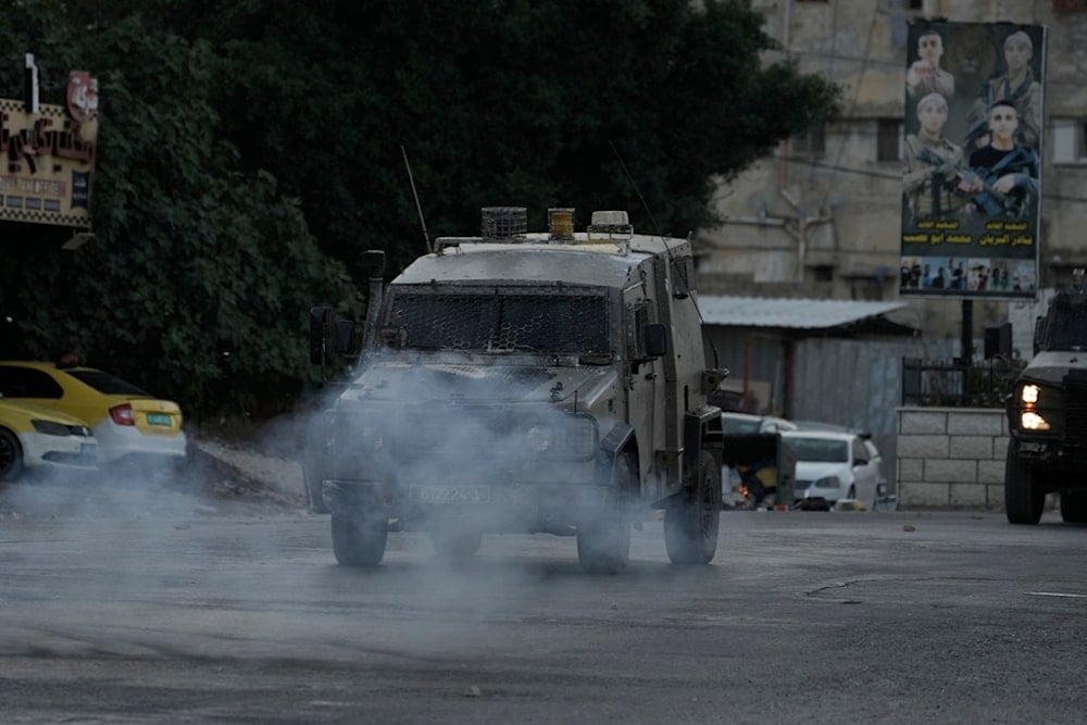 Smoke from explosives thrown by Palestinians at Israeli occupation forces' armored vehicles following a deadly raid in the Balata refugee camp in the West Bank city of Nablus, June 3, 2024. (AP)