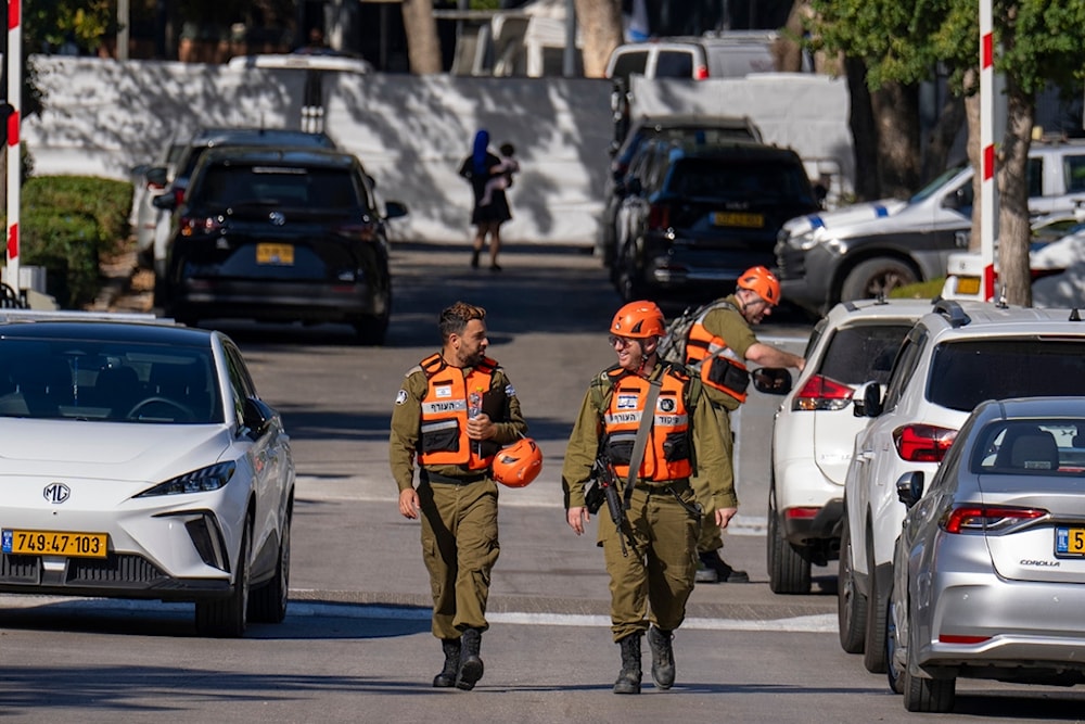 Officers from the Israeli Home Front Command military unit walk on a road near where Israel's government says a drone launched toward Israeli Prime Minister Benjamin Netanyahu's house in Caesarea, Oct. 19, 2024. (AP)