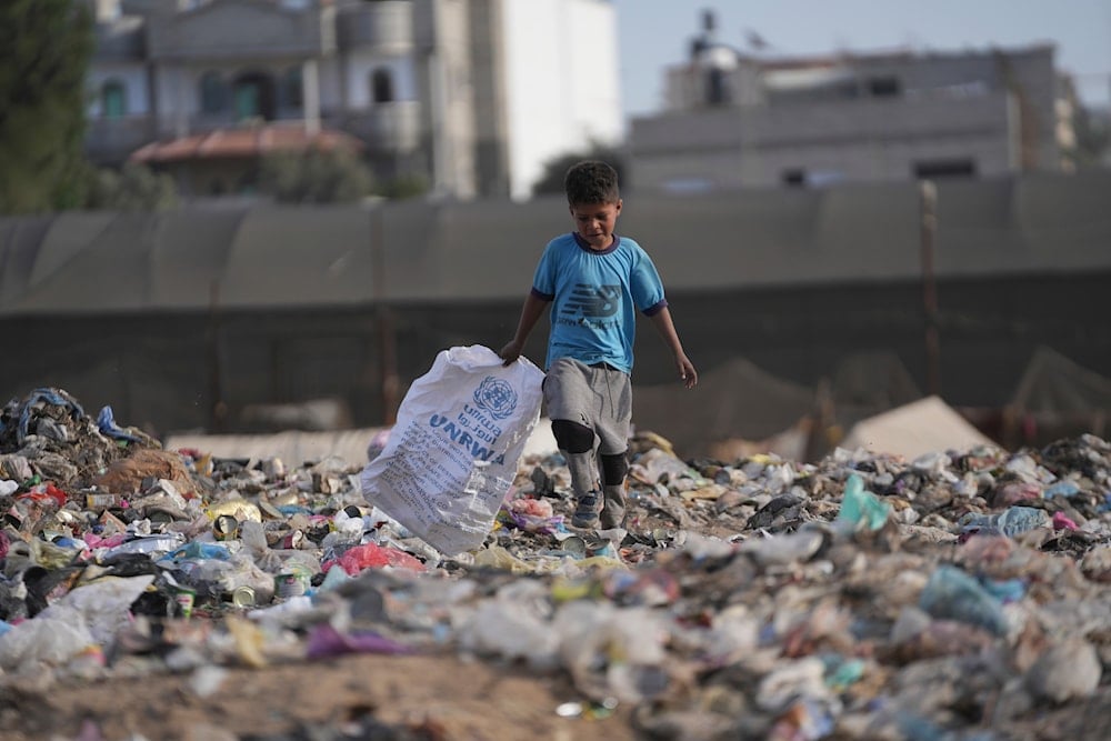 A Palestinian kid sorts through trash at a landfill in Zawaida, Gaza Strip, on November 17, 2024. (AP)