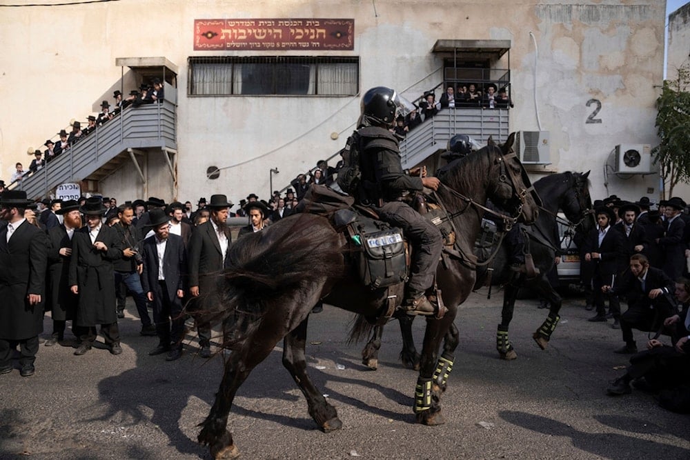 Israeli police officers scuffle with ultra-Orthodox Jewish men during a protest against a potential new draft law in occupied al-Quds, Thursday, Oct. 31, 2024. (AP Photo/Ohad Zwigenberg)