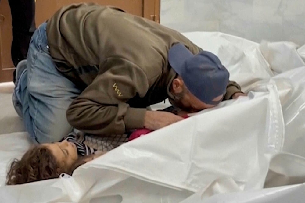 A Palestinian kisses a relative killed in Israeli airstrikes, in a morgue in the city of Khan Younis, southern Gaza Strip, Friday, Oct. 25, 2024. (AP)