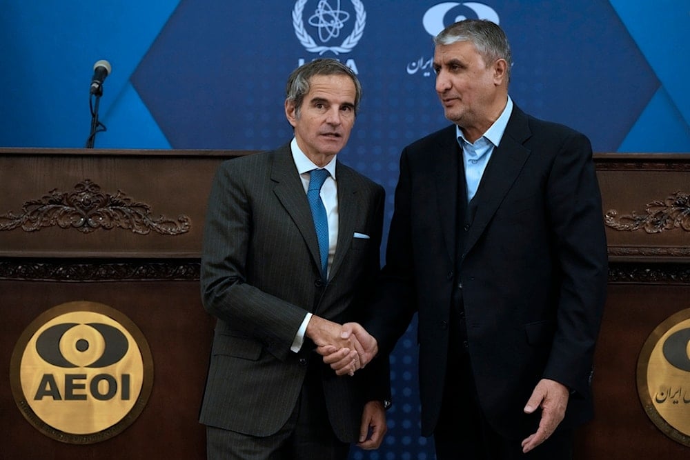 International Atomic Energy Agency Director General Rafael Mariano Grossi, left, and Iran's Atomic Energy Organization head Mohammad Eslami shake hands for media at the conclusion of their press conference in Tehran, Iran, November 14, 2024 (AP)