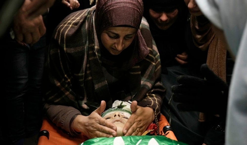  The mother of Amr al-Najjar, 11, touches his face during his funeral in the West Bank village of Burin, near Nablus, Tuesday, March 5,2024. (AP)