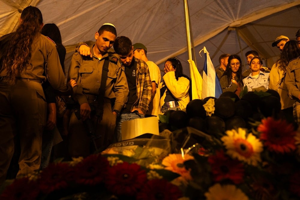 Israeli soldiers and relatives mourn during the funeral of captain Yogev Pazi, who was killed in Gaza, at the cemetery of Giv'ot Bar, southern occupied Palestine, Monday, November 18, 2024 (AP)