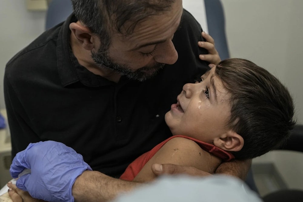  Hassan Mikdad, holds his son Hussein Mikdad, who was injuired on Oct. 2 in an Israeli airstrike at a densely-populated neighborhood south of Beirut, as he cries during a check up by his doctor, on November 5,2024. (AP)