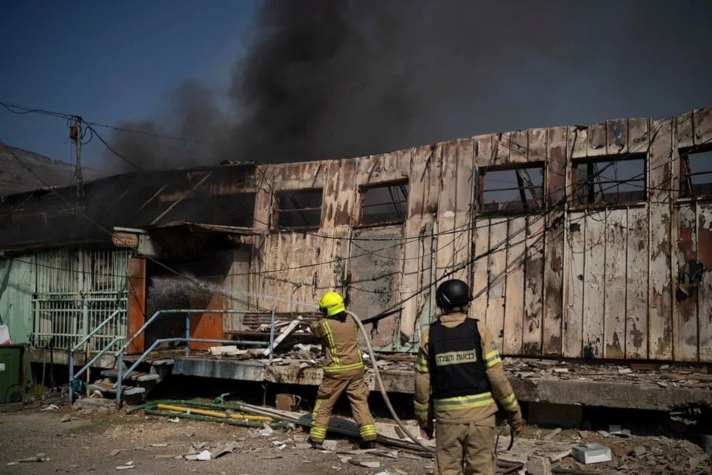 Firefighters work to extinguish a fire after a rocket, fired from Lebanon, hit a local municipality storage in Kiryat Shmona, northern Palestine, September 24, 2024. (AP)