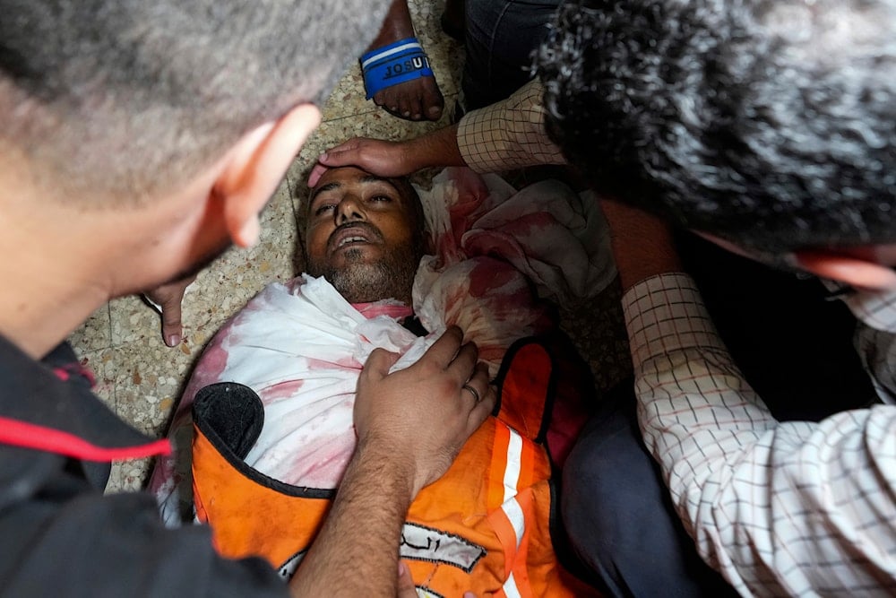 Palestinians mourn their colleague civil defense member killed in the Israeli bombardment of Nuseirat refugee camp, at the morgue of al-Aqsa Martyrs Hospital in Deir al Balah, central Gaza Strip on June 27, 2024. (AP)