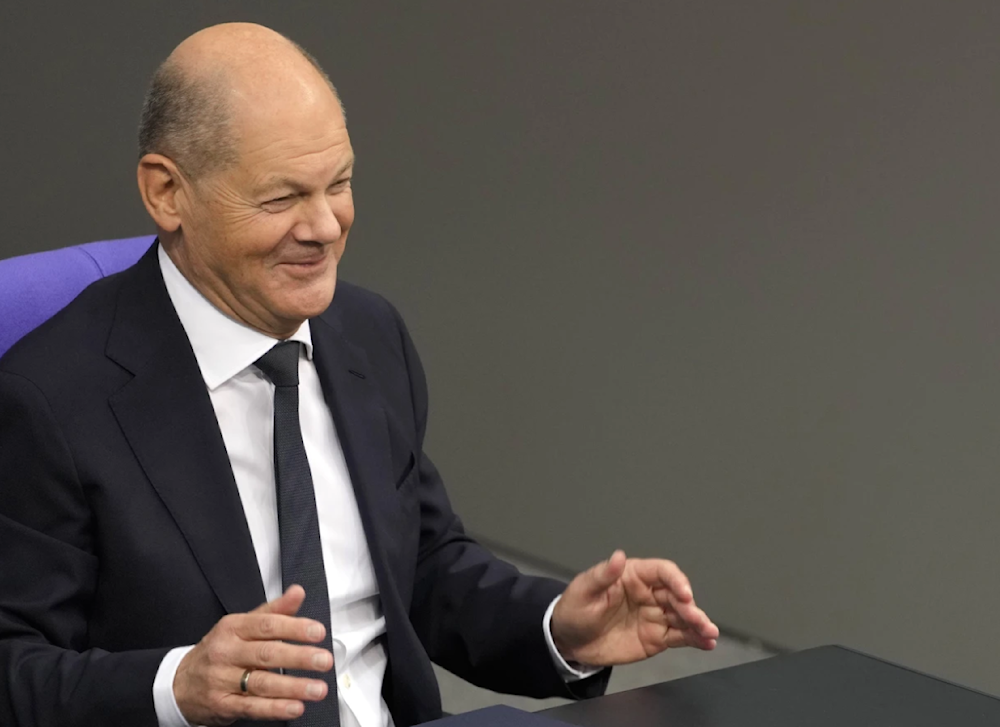 German Chancellor Olaf Scholz smiles during a plenary session in the German parliament in Berling on November 13, 2024. (AP)