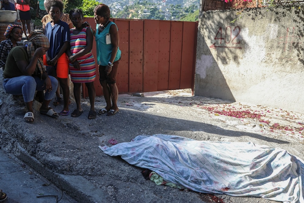 Residents gather before a person killed in an attack by gang members, in the Pétion-Ville neighborhood of Port-au-Prince, Haiti, Tuesday, November 19, 2024 (AP)