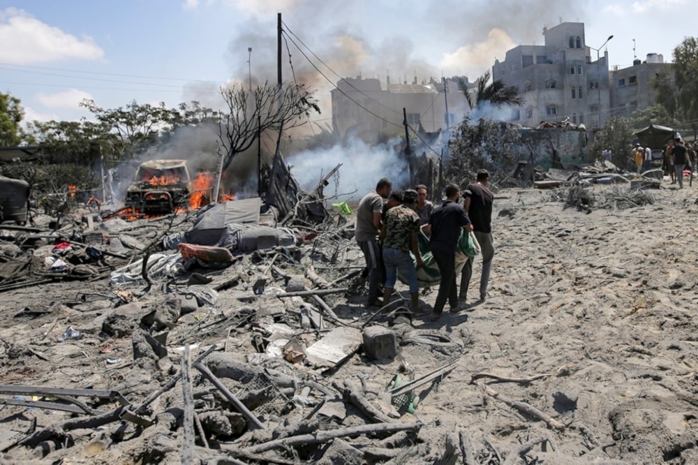 Palestinians evacuate a body from a residential builiding bombed by an Israeli warplanes on Khan Younis, southern Gaza Strip, Palestine, July 13,2024. (AP)