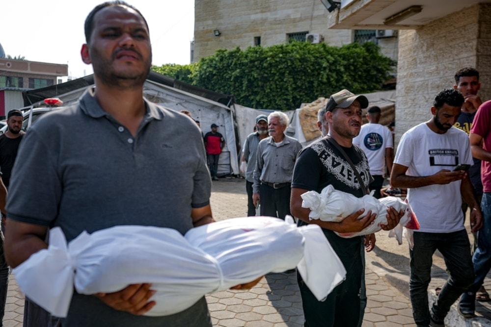  Palestinians hold the bodies of their relatives killed in the Israeli bombardment of the Gaza Strip, at a hospital in Deir al-Balah, on July 21, 2024. (AP)