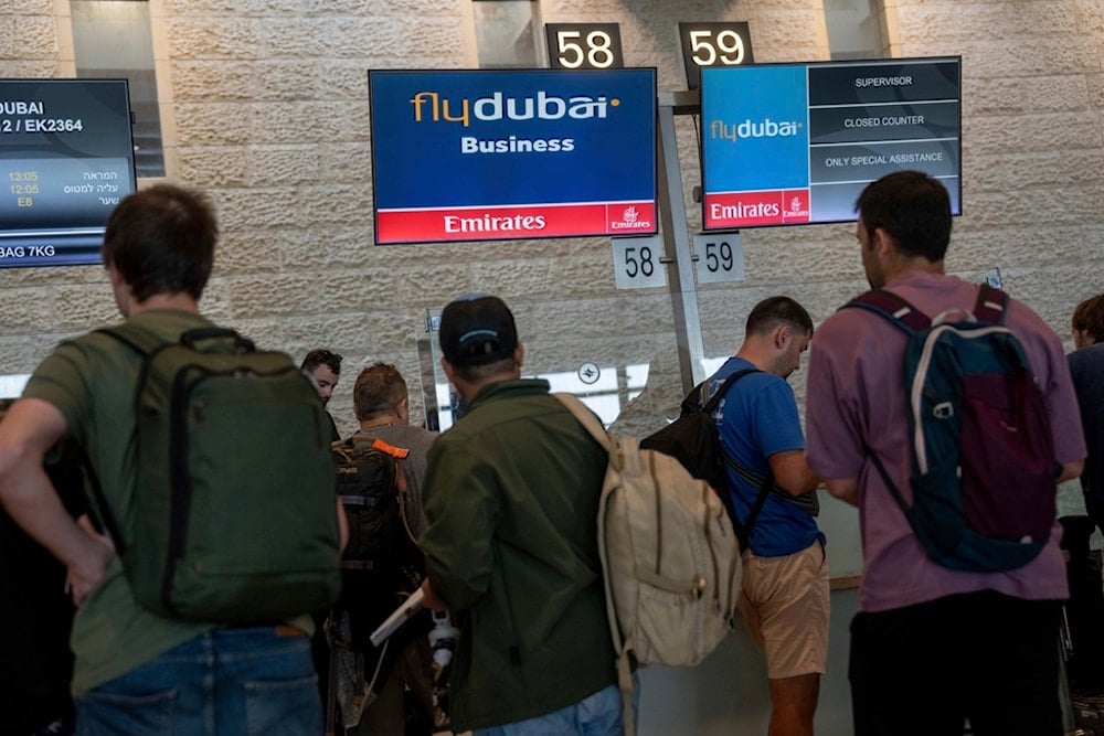 Travelers line up for check at Fly Dubai airline counter at Ben Gurion International Airport in al-Lydd, occupied Palestine, Sunday, Nov. 10, 2024. (AP)