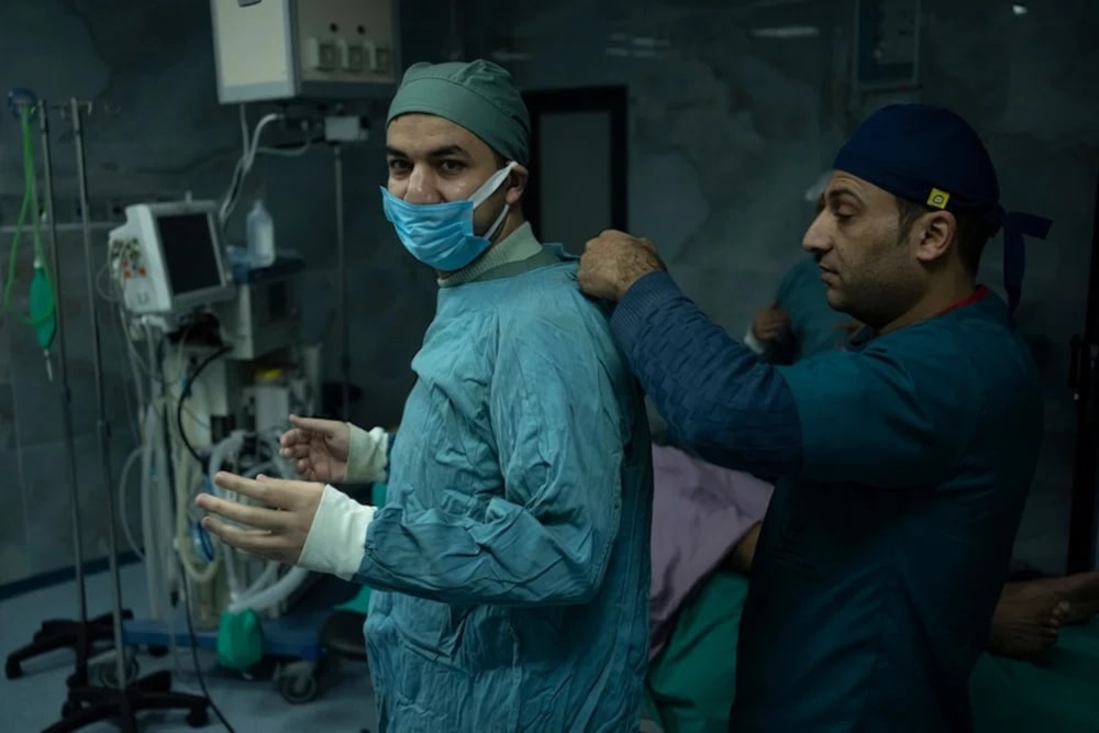 Dr. Suhaib Alhamss, the director of the Kuwaiti Hospital in Gaza's southern town of Rafah, gets ready to perform surgery on Thursday, January 11, 2024 (AP)