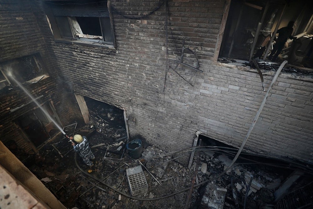 A firefighter hoses down a building hit in an Israeli airstrike in Damascus, Syria, Thursday, Nov. 14, 2024. (AP)