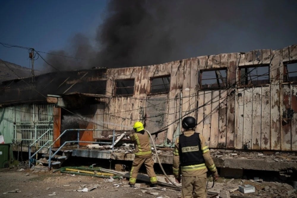 Firefighters work to extinguish a fire after a rocket, fired from Lebanon, hit a local municipality storage in Kiryat Shmona, northern Palestine, September 24, 2024. (AP)