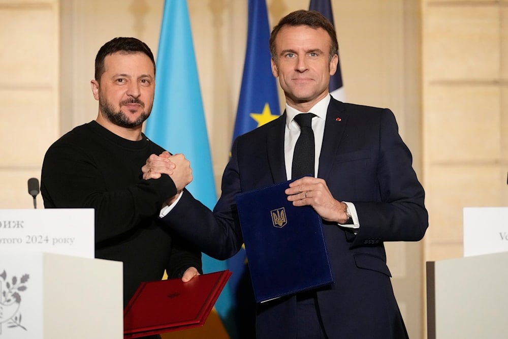 French President Emmanuel Macron, right, and his Ukrainian counterpart Volodymyr Zelenskyy shake hands after signing an agreement, on February 16, 2024 at the Elysee Palace in Paris. (AP)