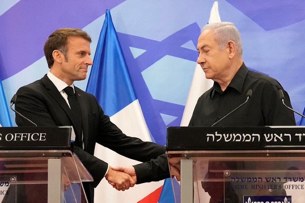 Israeli Prime Minister Benjamin Netanyahu, right, shakes hands with French President Emmanuel Macron during a joint press conference in occupied al-Quds, Oct. 24, 2023. (AP)