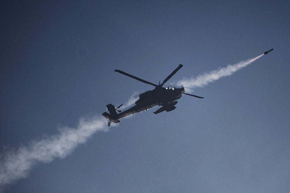 An Israeli Apache helicopter fires a missile towards southern Lebanon as seen from northern occupied Palestine, Sunday, Oct. 13, 2024. (AP)