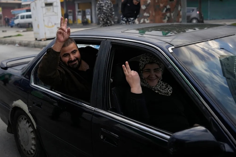  People flash victory signs as they return to their villages in Tyre. (AP)