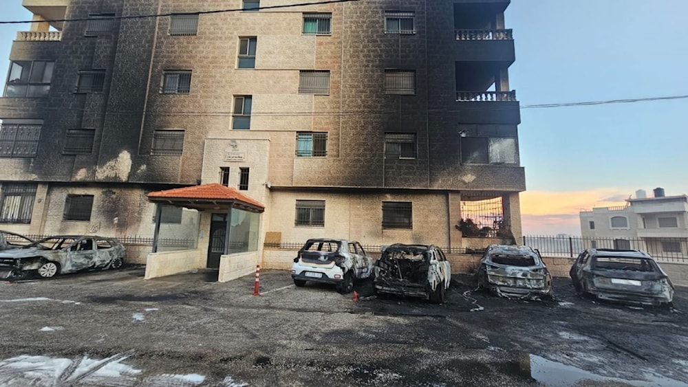 Palestinian vehicles and the front of a residential building burned by Israeli settlers during an attack on al-Bireh and Deir Dibwan, November 4, 2024 (Social Media)