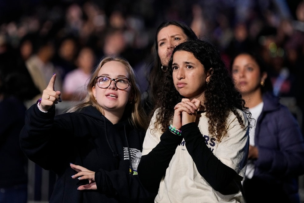 Supporters of Democratic presidential nominee Vice President Kamala Harris look at election results during an election night campaign watch party Tuesday, November 5, 2024, on the campus of Howard University in Washington (AP)