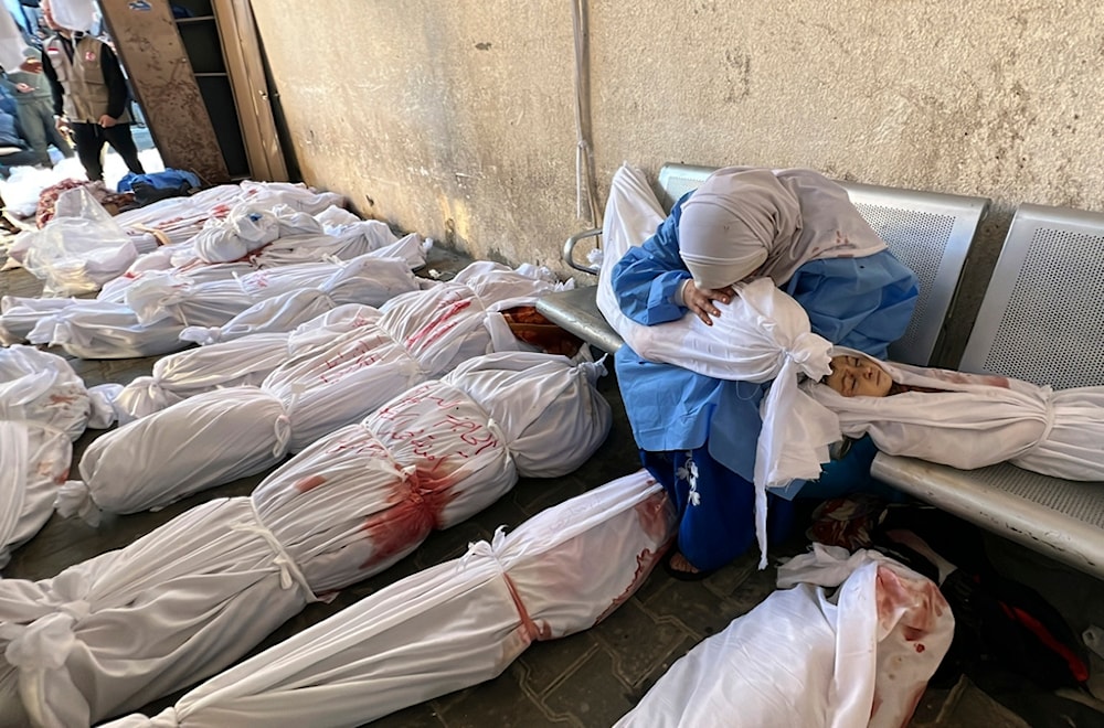 A Palestinian woman reacts over the body of a child as she sits by bodies of Palestinians killed by Israeli airstrikes on Jabalia refugee camp, at the Indonesian hospital, northern Gaza Strip, Nov. 18, 2023. (AP)