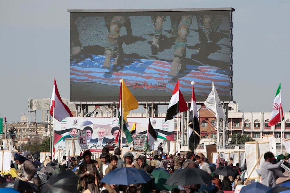 Yemenis shout slogans as a screen displays soldiers stepping on an American flag during a pro-Palestine rally in Sanaa, Yemen, Friday, Nov. 1, 2024. (AP)