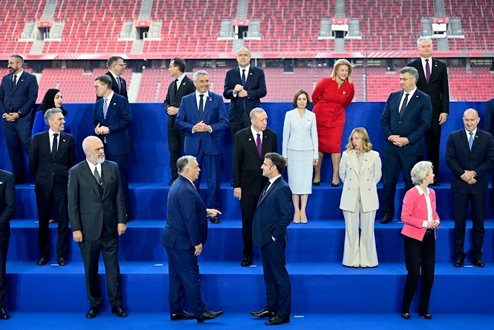 Hungary's Prime Minister Viktor Orban, center left front, speaks with French President Emmanuel Macron as other leaders pose during a group photo during the EPC Summit at the Puskas Arena in Budapest, Nov. 7, 2024. (AP)