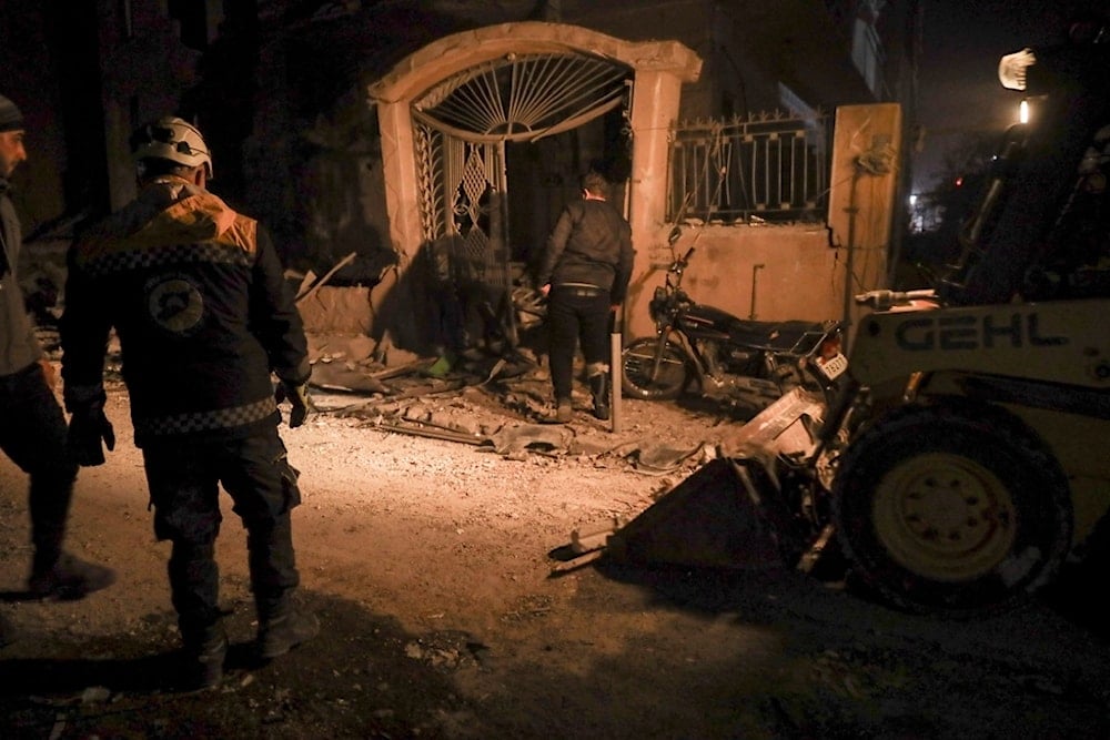 Residents inspect the site of an air strike in Idlib, Syria, Sunday, December 1, 2024 (AP)