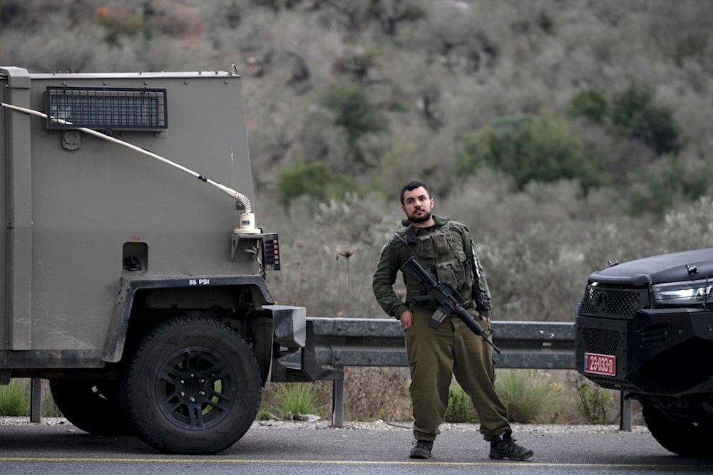 An Israeli soldier stands at the site of a shooting attack targeting an Israeli bus that injured at least three people, near the West Bank settlement of Ariel, Friday, Nov. 29, 2024. (AP)