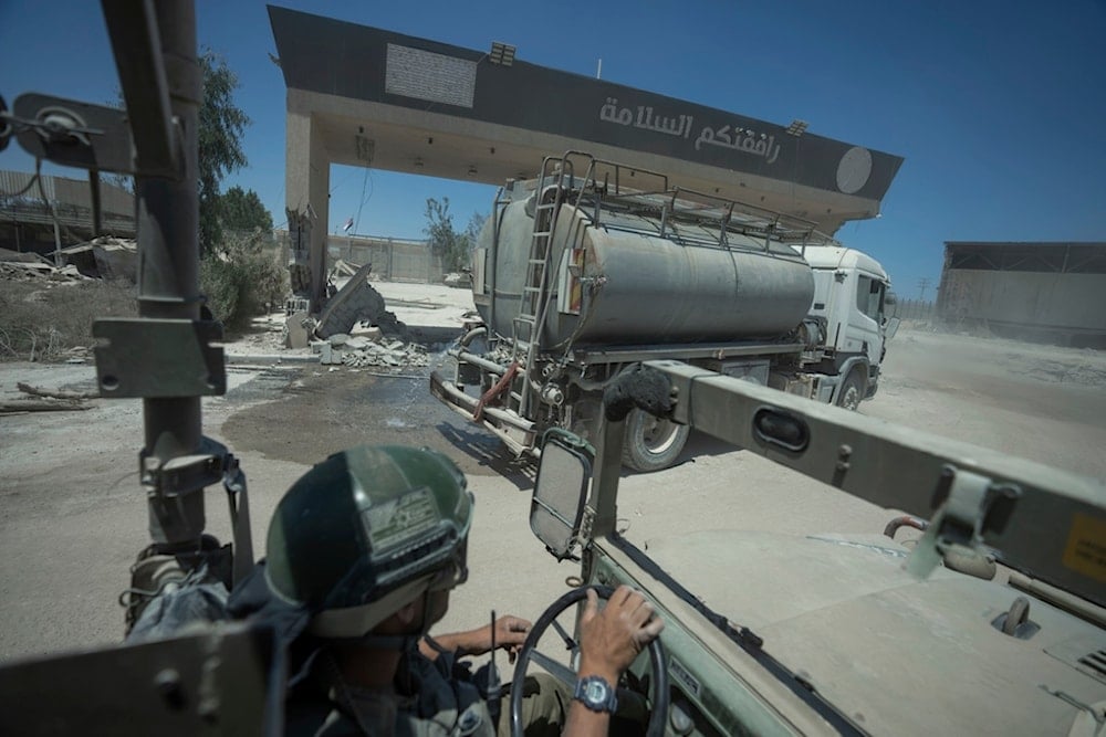 An Israeli soldier drives on the Gaza side of the Karem Abu Salem crossing between 