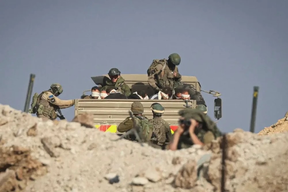 Israeli soldiers detained blindfolded Palestinian men in a military truck on a road in the Zaytun district of the southern part of the Gaza Strip on November 19, 2023 (AFP via Getty Images)