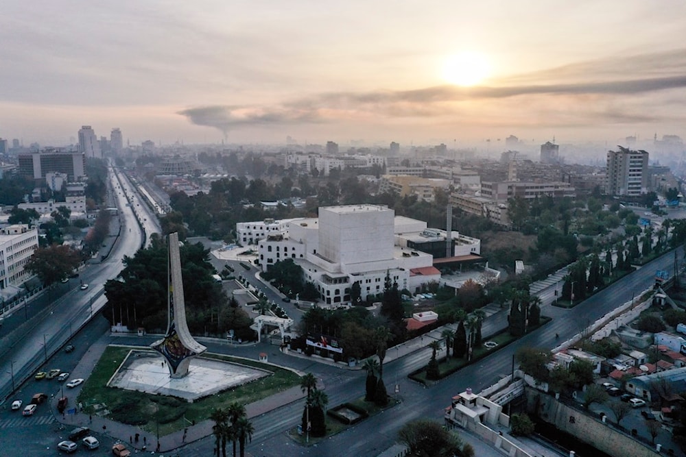 An aerial view shows a column of black smoke in the background, caused by an Israeli airstrike, as seen from Umayyad Square in Damascus, Syria, Tuesday, December 10, 2024 (AP)