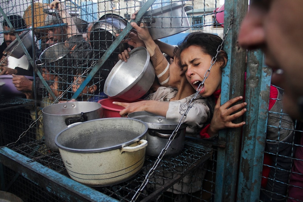 Palestinians line up to receive free meals at Jabaliya refugee camp in the Gaza Strip on March 18, 2024. (AP)