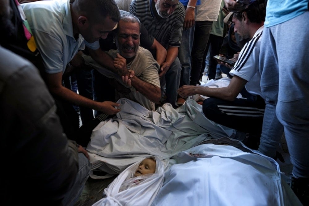 Palestinians mourn for relatives killed in the Israeli bombardment of the Gaza strip at a hospital morgue in Deir al-Balah in October 2024. (AP)