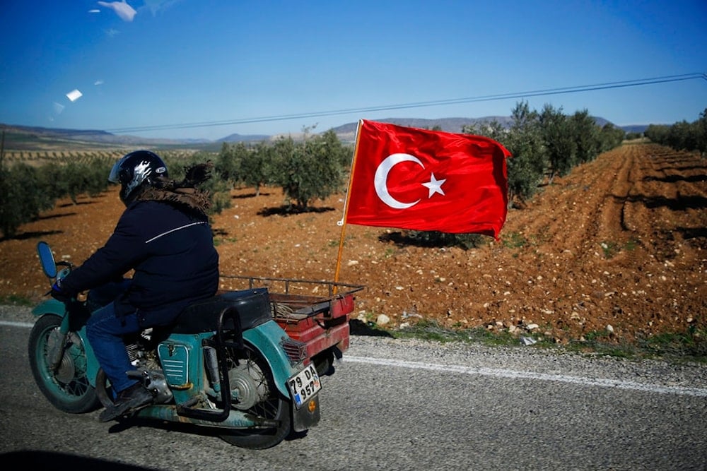 A Turkish motorcyclist drives on the outskirts of the border town of Kilis, Turkey, in support of Turkish troops, Tuesday, Jan. 30, 2018. (AP)