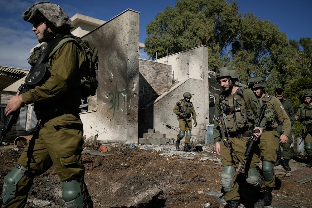 Israeli soldiers inspect the site where a rocket fired from Lebanon landed in a backyard in Kiryat Shmona, northern 